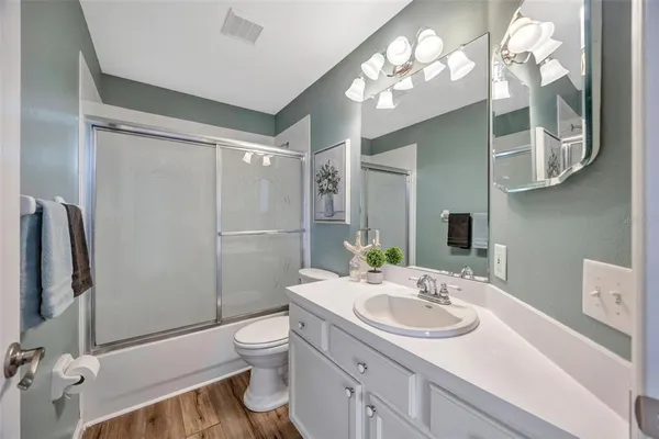 a bathroom with a sink toilet double vanity and shower