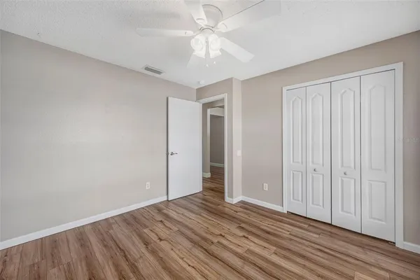an empty room with closet and a ceiling fan