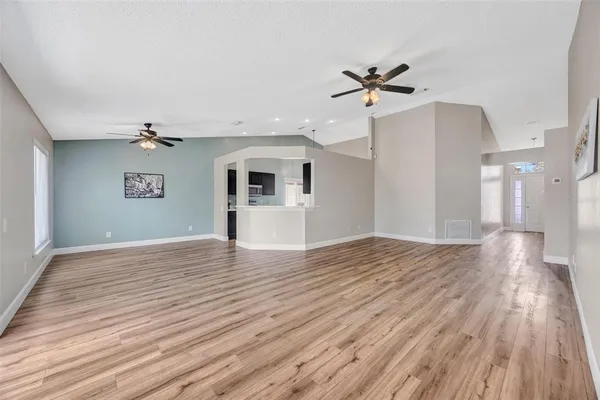 a view of a livingroom with wooden floor and a ceiling fan