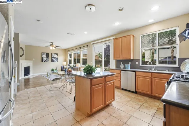 a kitchen with stainless steel appliances granite countertop a stove a sink a microwave a refrigerator and cabinets