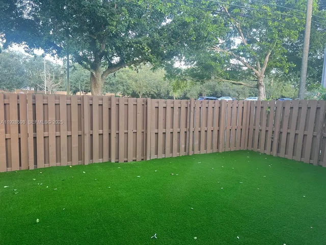 a view of a yard with wooden fence