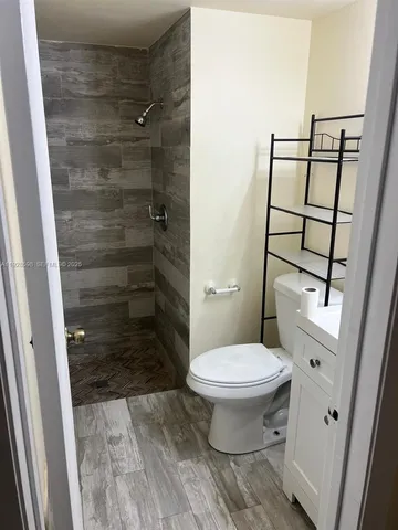 a bathroom with a toilet and a shower