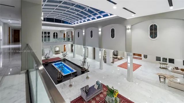 a living room with furniture floor to ceiling window and wooden floor