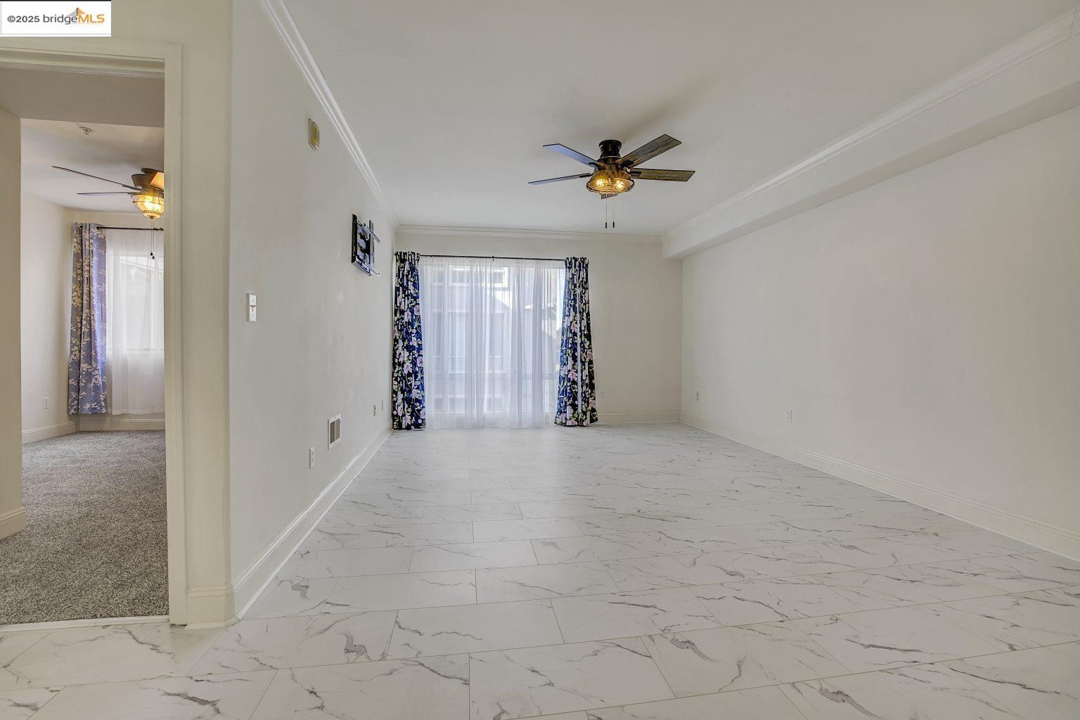 1515 14th Avenue, Unit 302 Oakland, CA 94606 - Photo 12 of 32 a view of an empty room and a bathroom with a ceiling fan