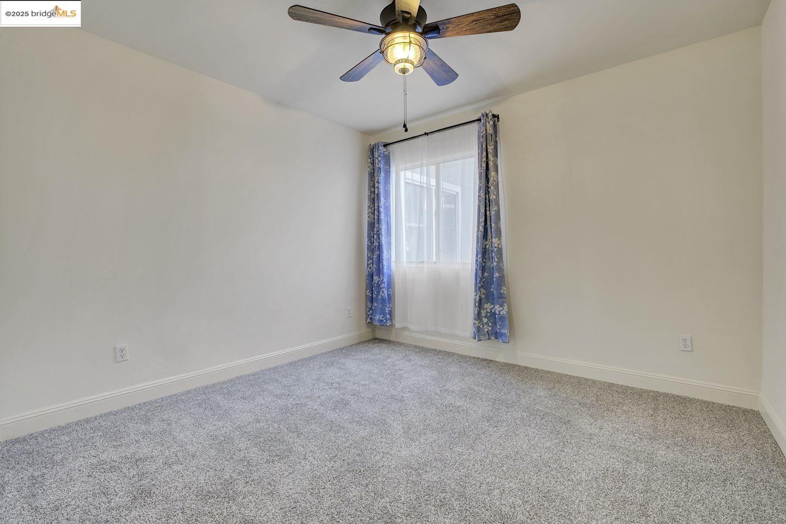 1515 14th Avenue, Unit 302 Oakland, CA 94606 - Photo 20 of 32 an empty room with fan and windows