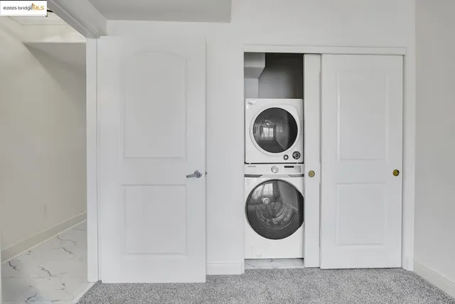 an empty room with chandelier fan and windows