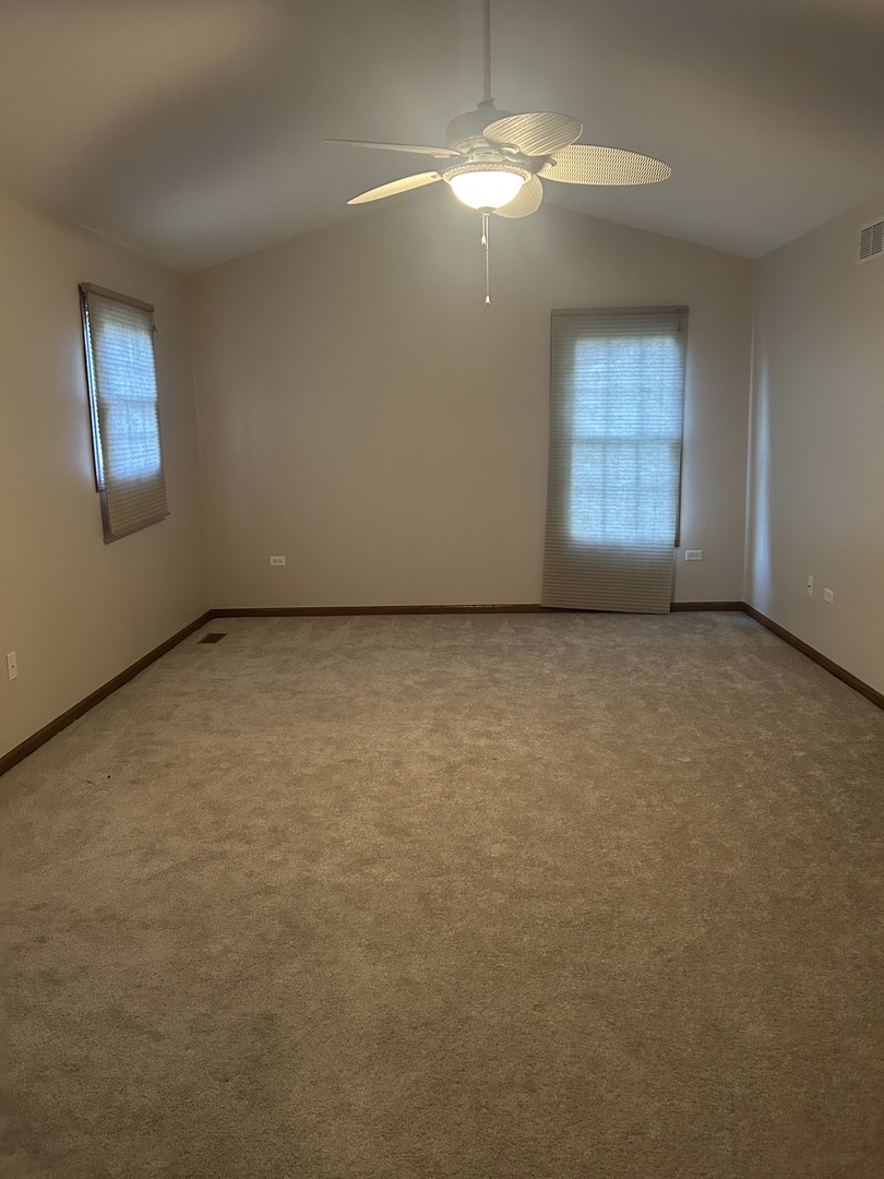 527 Springwood Lane Bolingbrook, IL 60440 - Photo 24 of 35 an empty room with chandelier fan and windows