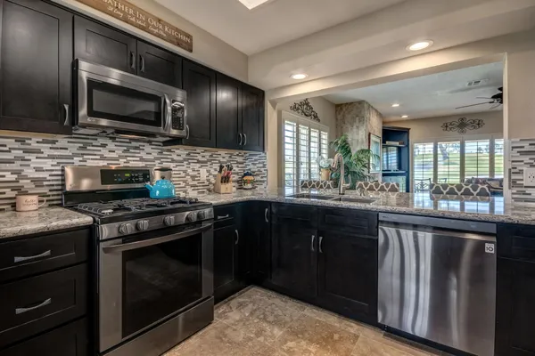 a kitchen with stainless steel appliances granite countertop a sink and stove