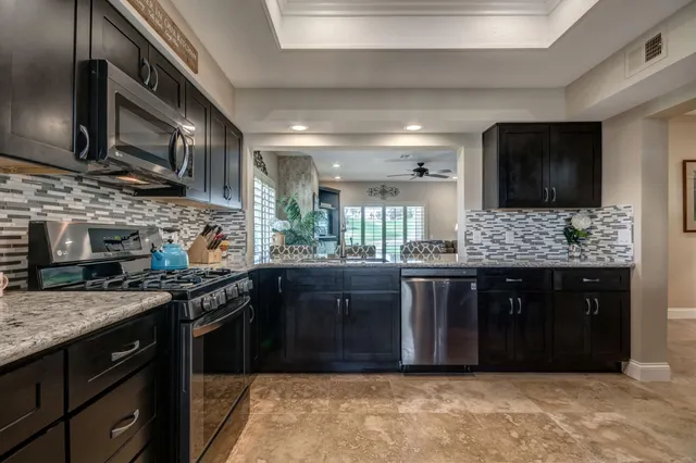a kitchen with stainless steel appliances granite countertop a sink and stove