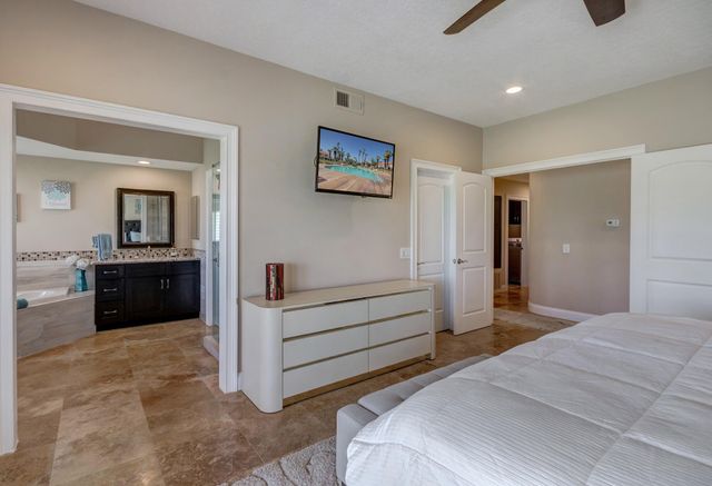 a spacious bedroom with a bed and a view of bathroom