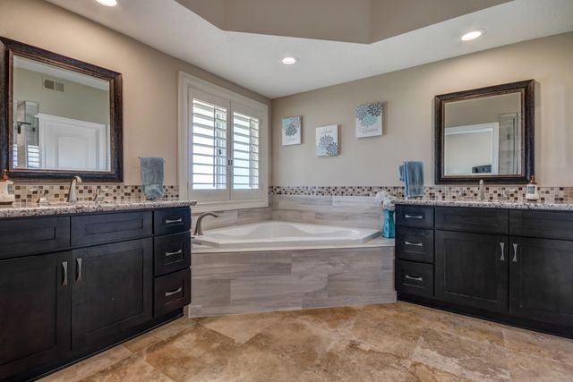 a spacious bathroom with a tub sink and mirror