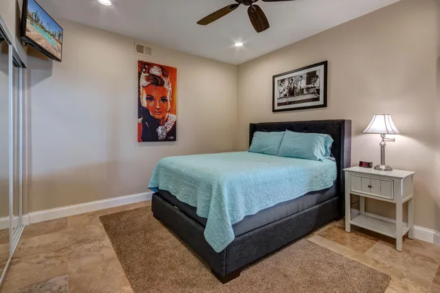 a bedroom with a bed and a painting on the wall