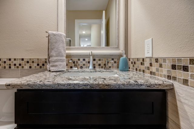 a bathroom with a granite countertop sink and a mirror