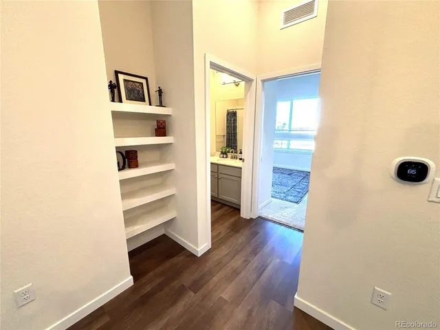 a view of a hallway with wooden floor and closet
