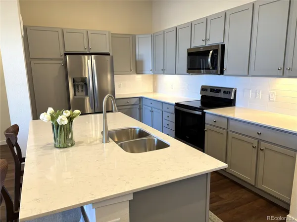 a kitchen with stainless steel appliances a refrigerator sink and microwave