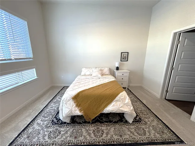 a bed sitting in a bedroom next to a window