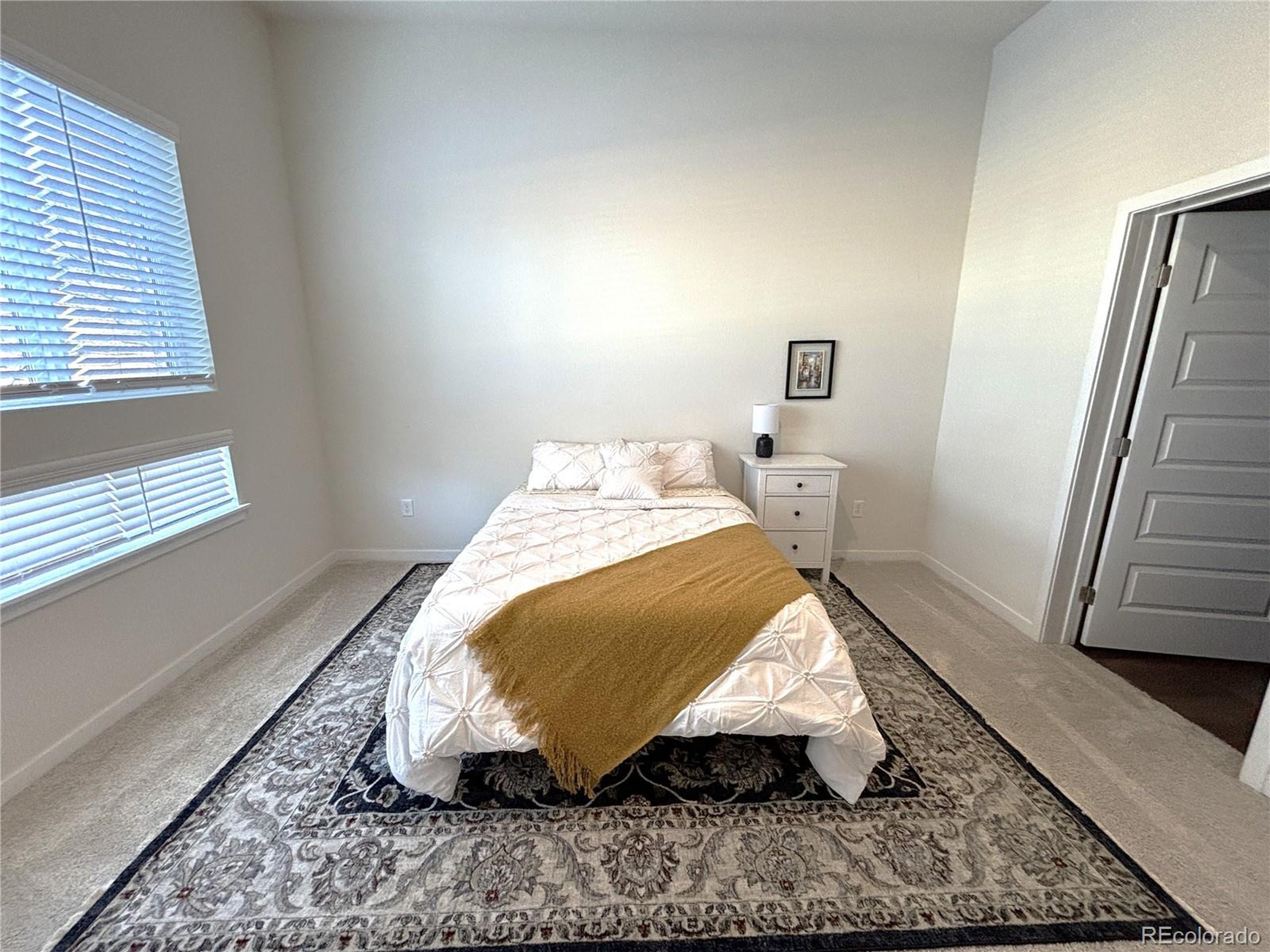 437 Interlocken Boulevard, Unit 102 Broomfield, CO 80021 - Photo 8 of 27 a bed sitting in a bedroom next to a window