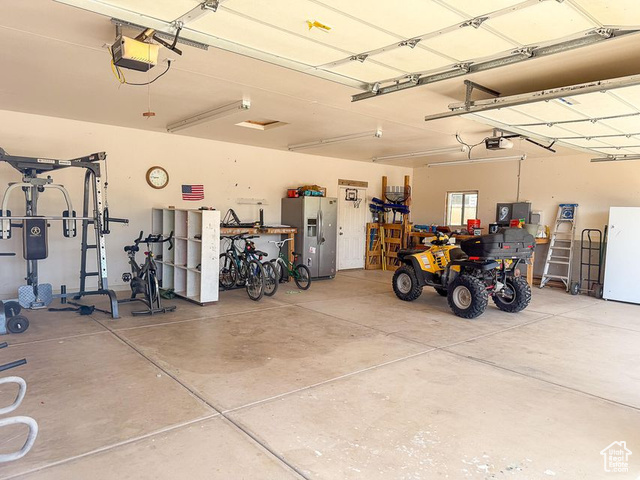 425 East Mule Deer Road Central, UT 84722 - Photo 50 of 72 Garage featuring stainless steel fridge, a garage door opener, and freestanding refrigerator