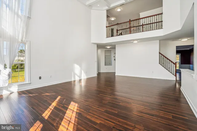 a kitchen with stainless steel appliances granite countertop a stove top oven a sink dishwasher a dining table and chairs with wooden floor