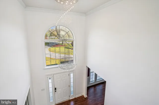 an empty room with a chandelier fan and closet area