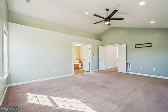 an empty room with closet and a ceiling fan