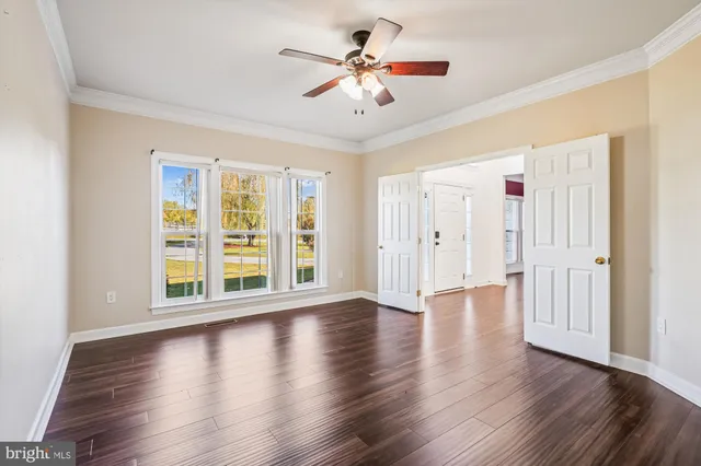 a view of a room with wooden floor and a ceiling fan