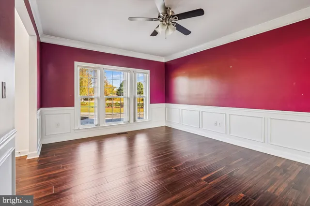 a view of room with hardwood floor and a ceiling fan