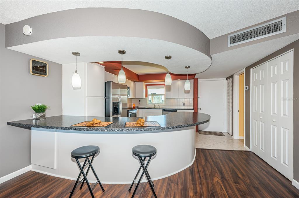 4725 Cove Circle, Unit 604 St. Petersburg, FL 33708 - Photo 13 of 53 a dining room with stainless steel appliances furniture a large window and wooden floor