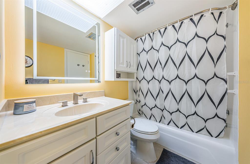 4725 Cove Circle, Unit 604 St. Petersburg, FL 33708 - Photo 20 of 53 a bathroom with a granite countertop sink and a mirror