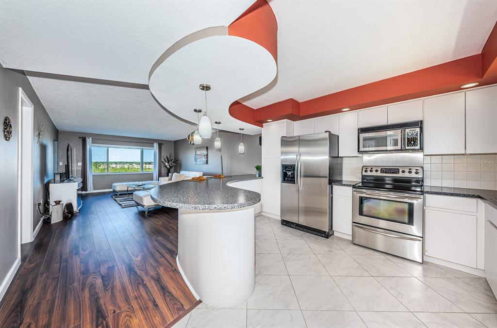 4725 Cove Circle, Unit 604 St. Petersburg, FL 33708 - Photo 2 of 53 a kitchen with stainless steel appliances granite countertop a stove and a refrigerator