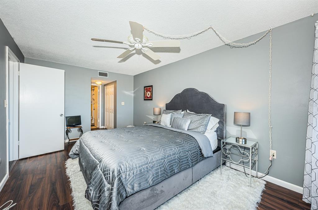 4725 Cove Circle, Unit 604 St. Petersburg, FL 33708 - Photo 31 of 53 a bedroom with a bed and wooden floor