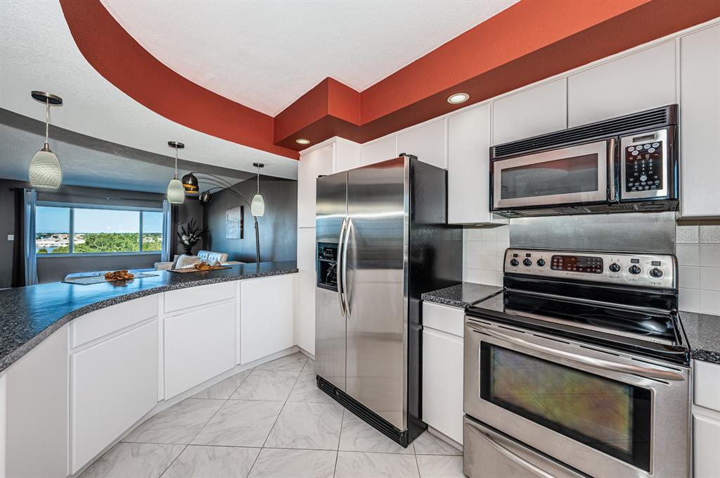 4725 Cove Circle, Unit 604 St. Petersburg, FL 33708 - Photo 9 of 53 a kitchen with stainless steel appliances granite countertop a refrigerator and a stove