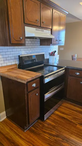 a kitchen with stainless steel appliances granite countertop a stove a sink and a refrigerator