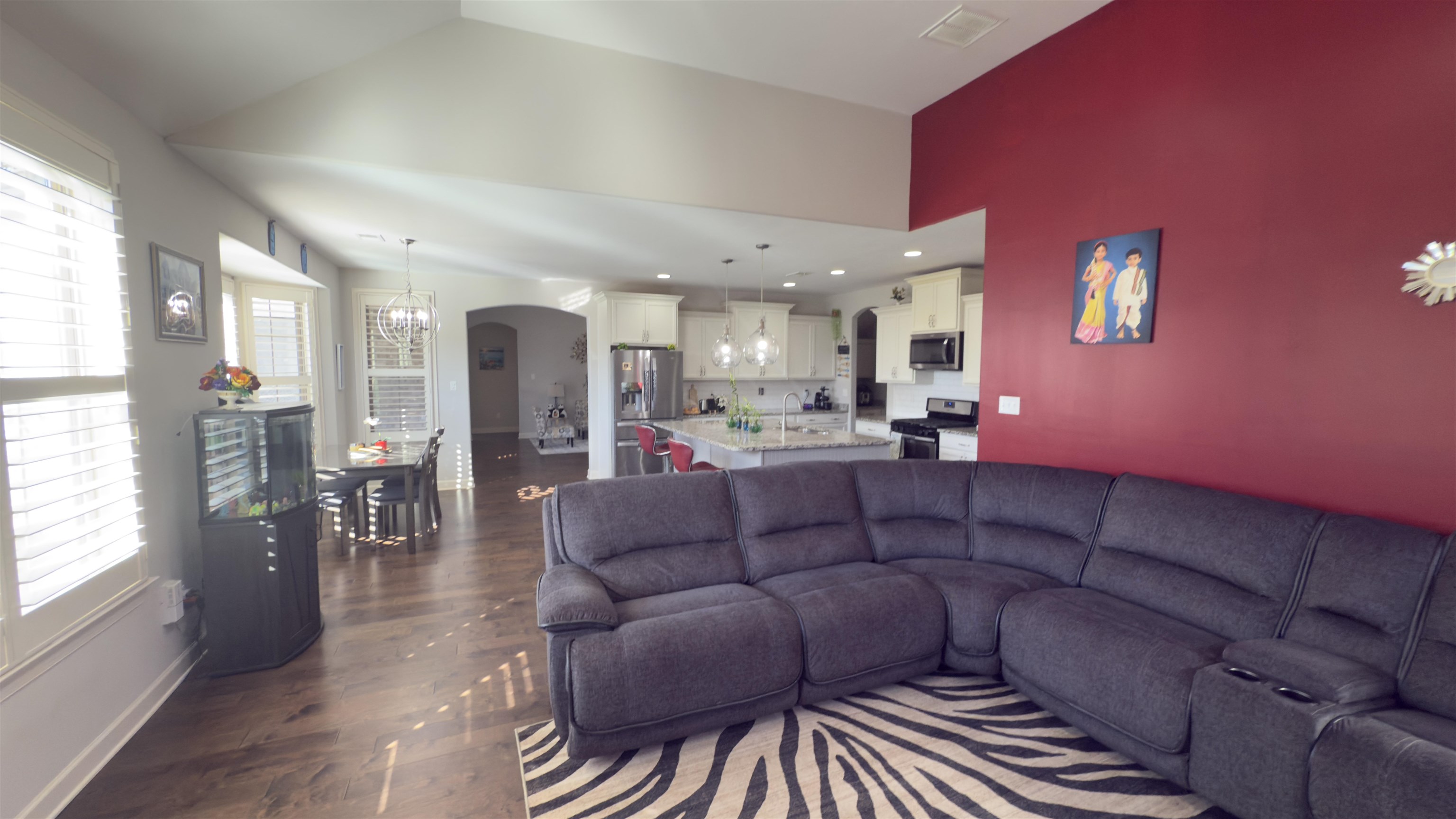 1217 Pilgrim Ridge Road Collierville, TN 38017 - Photo 11 of 33 Living area with a chandelier, arched walkways, vaulted ceiling, and dark wood-type flooring