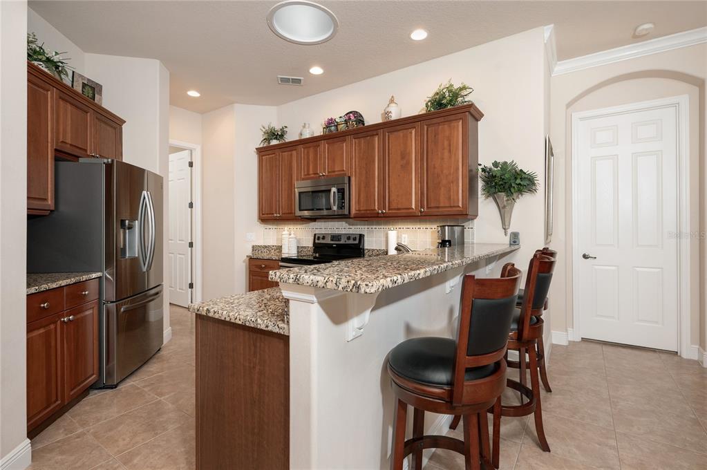 202 Lourdan Court DeBary, FL 32713 - Photo 13 of 38 a kitchen with stainless steel appliances granite countertop a table chairs microwave and refrigerator