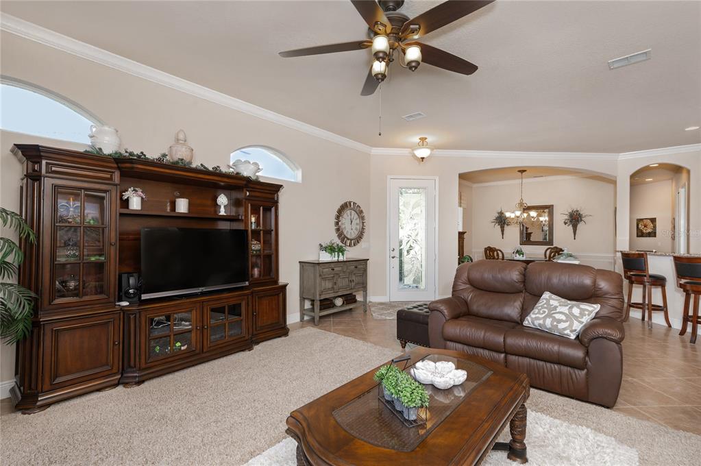202 Lourdan Court DeBary, FL 32713 - Photo 9 of 38 a living room with furniture a ceiling fan and a flat screen tv