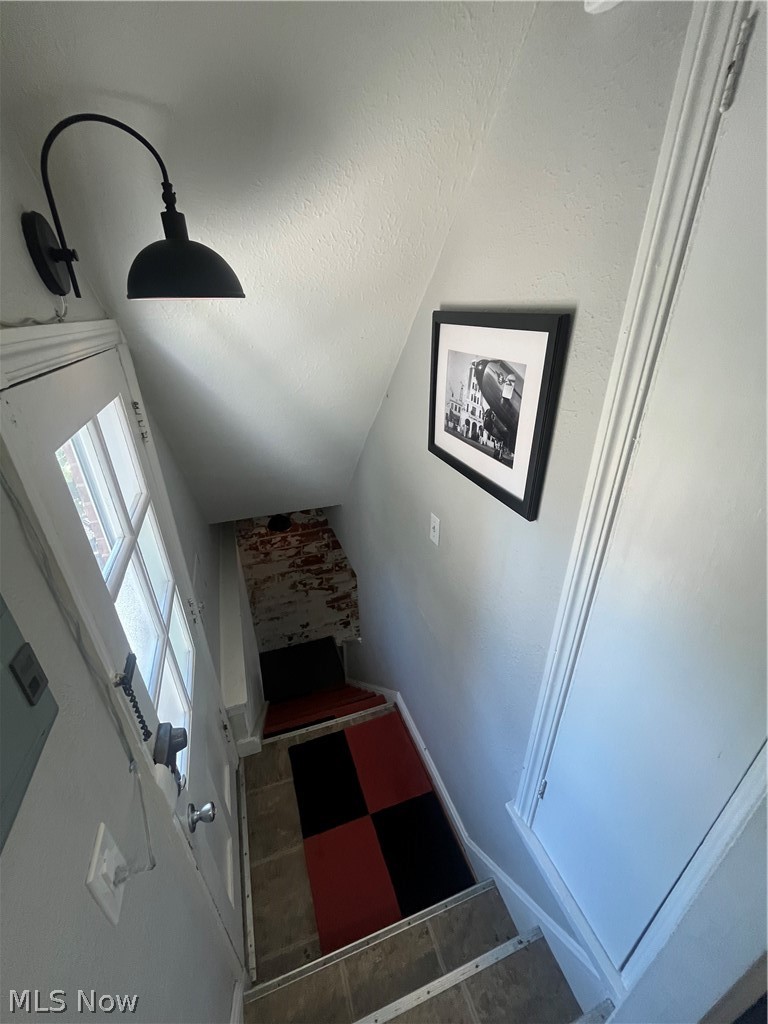 3471 Warren Road Cleveland, OH 44111 - Photo 3 of 17 Stairway featuring a textured ceiling and tile patterned floors