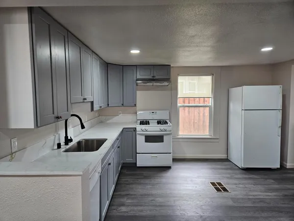a kitchen with stainless steel appliances granite countertop a sink stove and refrigerator