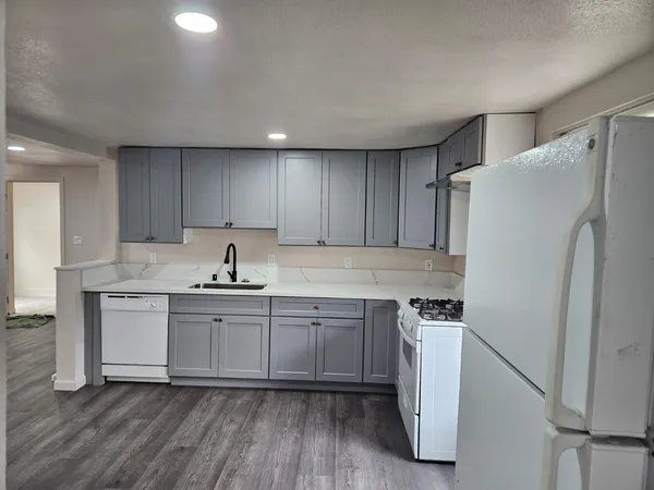 a kitchen with stainless steel appliances a sink a stove a refrigerator and cabinets