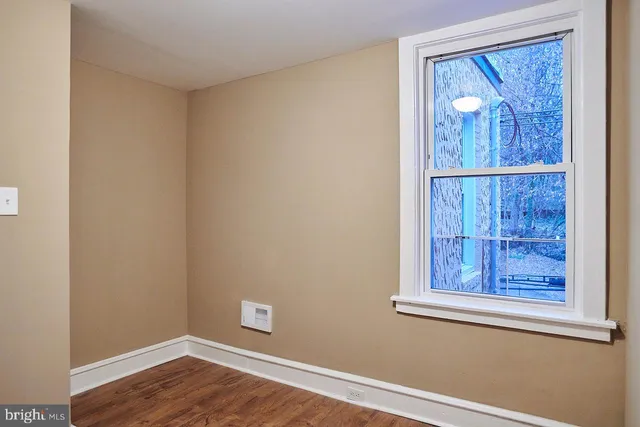 an empty room with wooden floor and a window