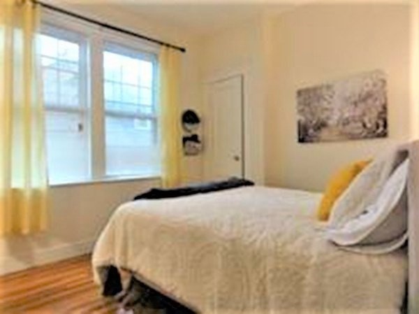153 Strathmore Road, Unit 8 Boston, MA 02135 - Photo 5 of 14 a bedroom with a bed and a large window