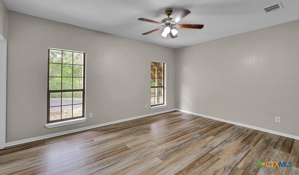 3900 Fox Ridge Road Lorena, TX 76655 - Photo 14 of 35 a view of an empty room with a window and wooden floor
