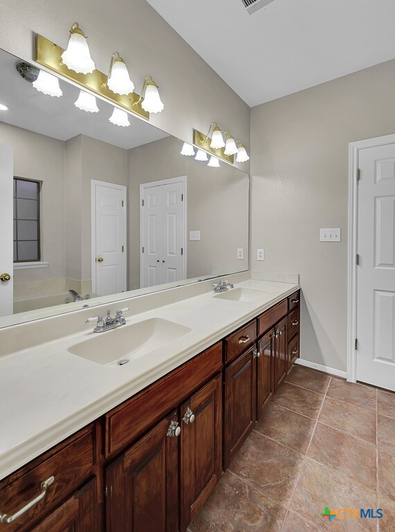 3900 Fox Ridge Road Lorena, TX 76655 - Photo 16 of 35 a spacious bathroom with a double vanity sink and a mirror
