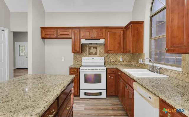 a kitchen with stainless steel appliances granite countertop a stove sink and cabinets