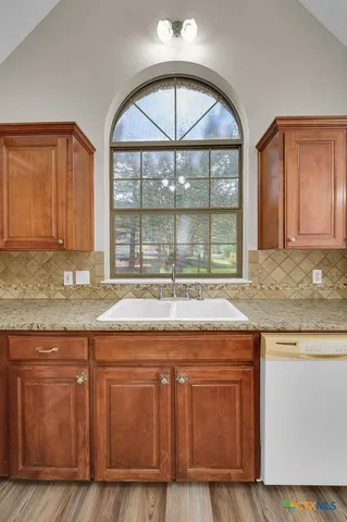 a kitchen with granite countertop a stove and a sink