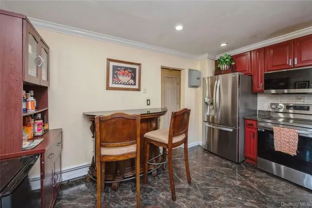 a view of kitchen with stainless steel appliances granite countertop a dining table and chairs