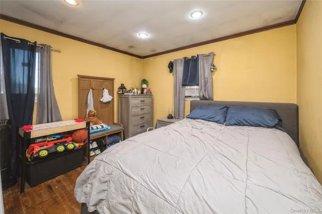 a bedroom with a bed and a dresser with mirror