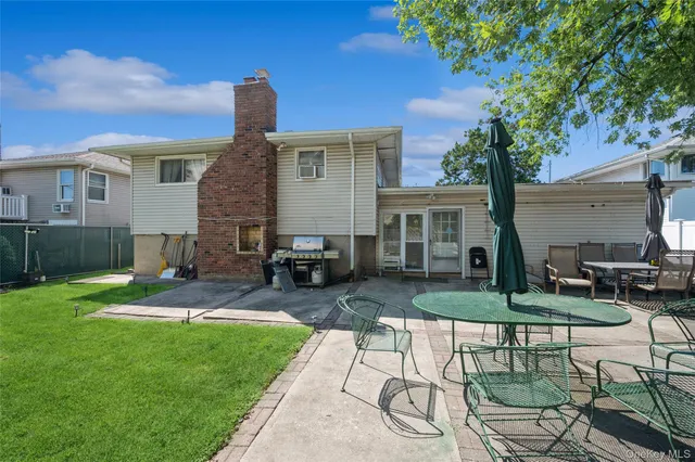 a view of a house with backyard and sitting area