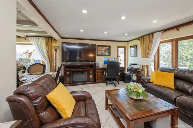 a living room with furniture kitchen view and a large window