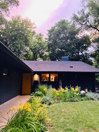 a front view of a house with a yard and flowers